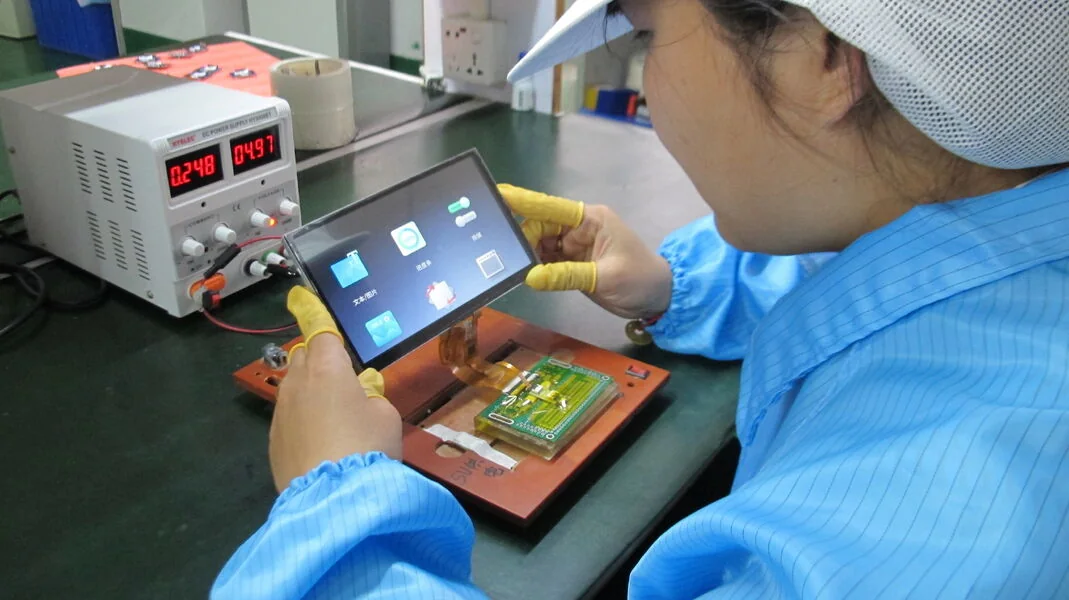 Engineer powering up a colour TFT module at a functional test bench