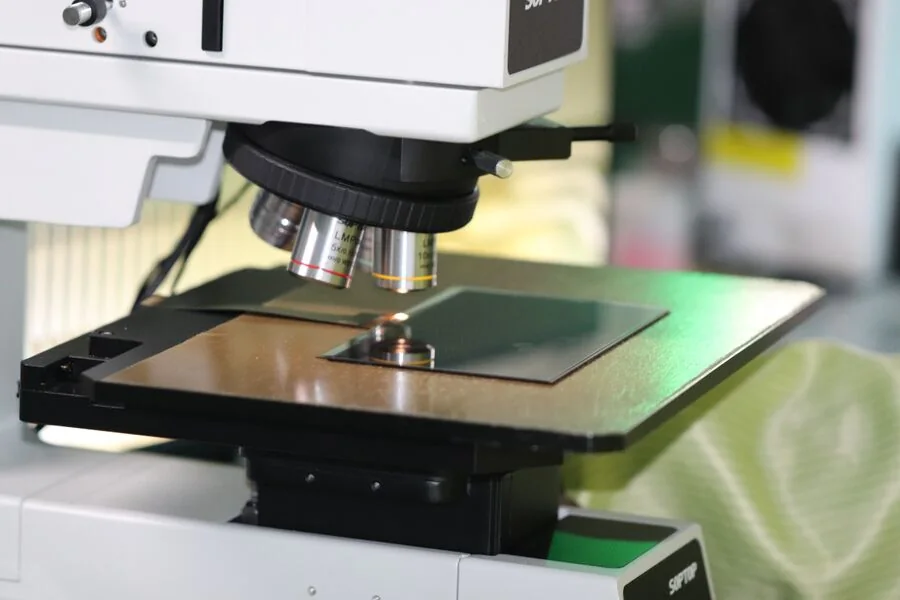 Optical measuring microscope with a glass panel on the stage